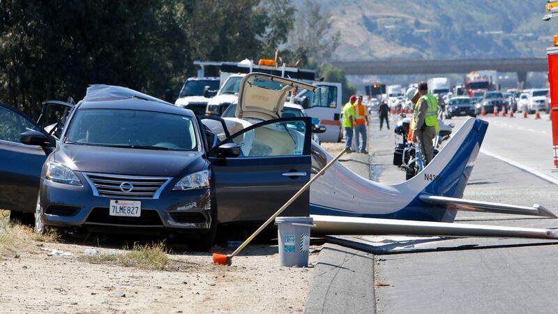 The plane struck the back of a car, resulting in the death of a woman in the car. Photograph: Don Boomer/San Diego Union-Tribune/AP