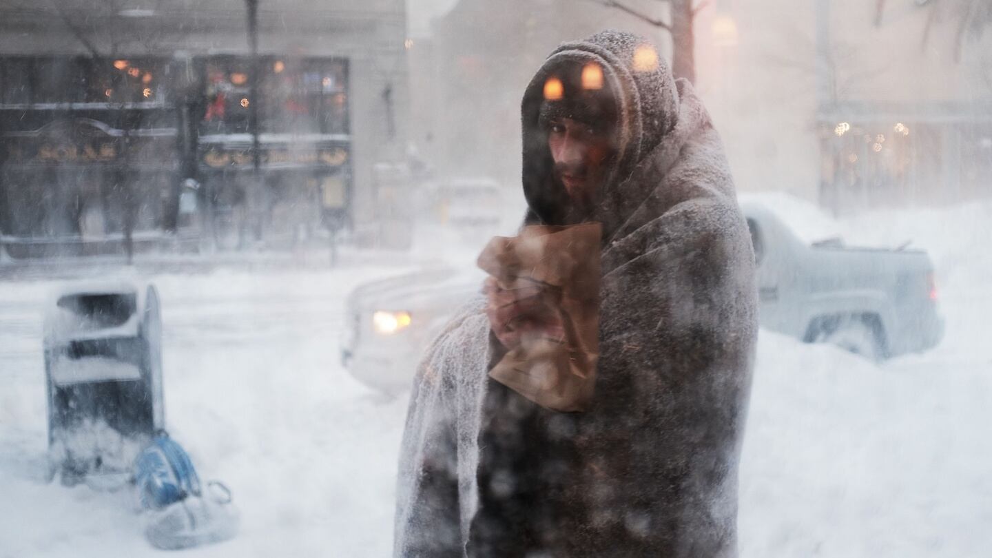 A homeless man pauses outside of a coffee shop on the streets of Boston as snow falls from a massive winter storm on Thursday. Photograph: Spencer Platt/Getty Images