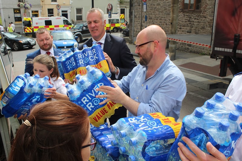 Labour senator Ged Nash and Coca Cola executives David Mulholland (left) and Paul McDonnell filling an Order of Malta ambulance with donated bottles of water in Drogheda. Photograph: Simon Carswell