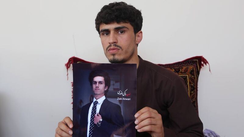 Zaki Anwari’s brother Nasir Anwari holds up a photo of his brother who died trying to escape the country. Photo: Bilal Guler/Anadolu Agency via Getty Images