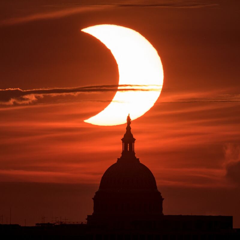 In this image taken from Arlington, Virginia, and released by Nasa, a partial solar eclipse rises behind the US Capitol. Photograph: Bill Ingalls/AFP/ via Getty Images