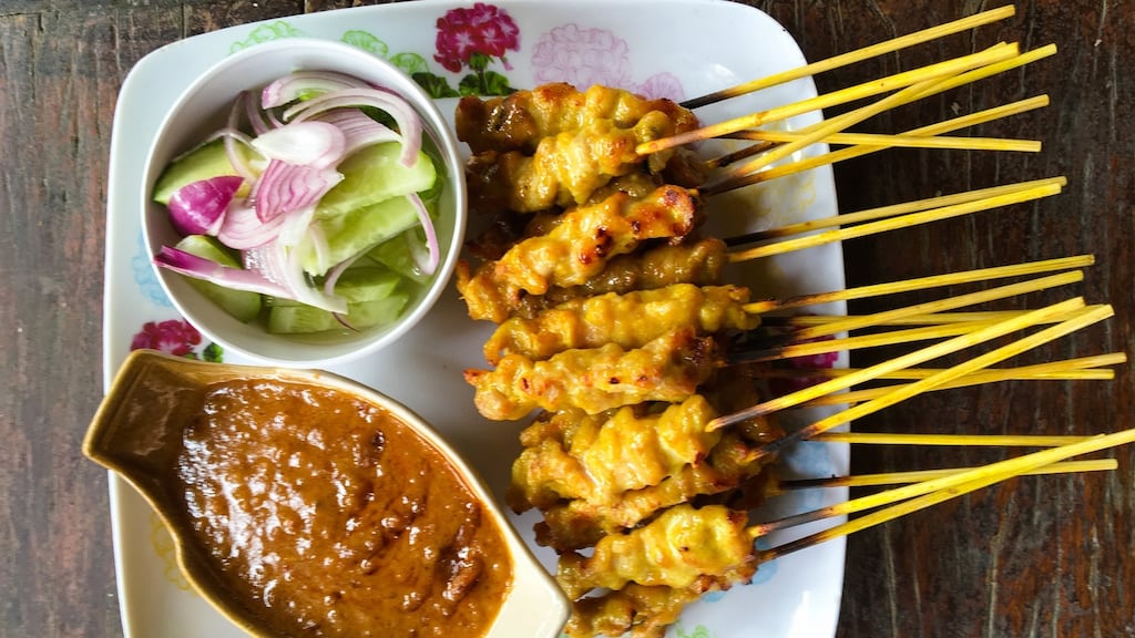 Trim a pineapple and jab a bunch of chicken skewers into it, like some demented poultry porcupine, and do not skimp on the Fake-Ass Spicy Peanut Sauce.