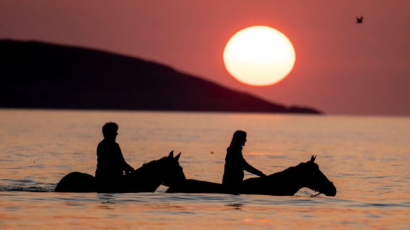 Hanna McDowell on her horse, Hero, and Jenny Doran on her horse, Neo, exercising in the sea at sunrise at Portmarnock Beach, Portmarnock, Co Dublin, on Sunday. Photograph: Tom Honan