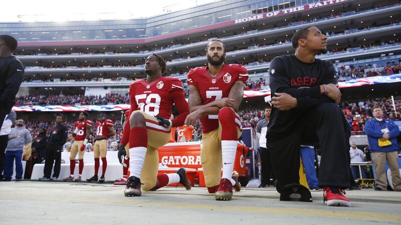 Colin Kaepernick (centre) takes a knee alongside San Franciso 49ers team-mates Eli Harold and Eric Reid. Photograph: Michael Zagaris/San Francisco 49ers/Getty Images