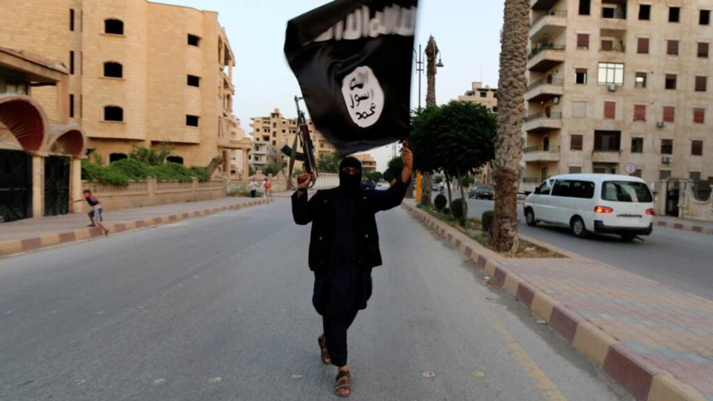 A member loyal to the Islamic State in Iraq and the Levant waves a flag in Raqqa last month. It has emerged insurgents have seized nucler materials from a university in the north of the country. Photograph: Reuters