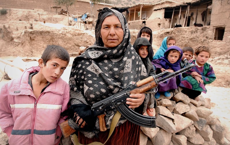 An example of the photography of Richard Mills: Commander Kaftar (53) pictured with her grandchildren at her home in the village of Tuli, central Afghanistan. The mujahedin commander fought against the Soviet Red Army, and the Taliban regime. Photograph: Richard Mills/Times Newspapers Ltd