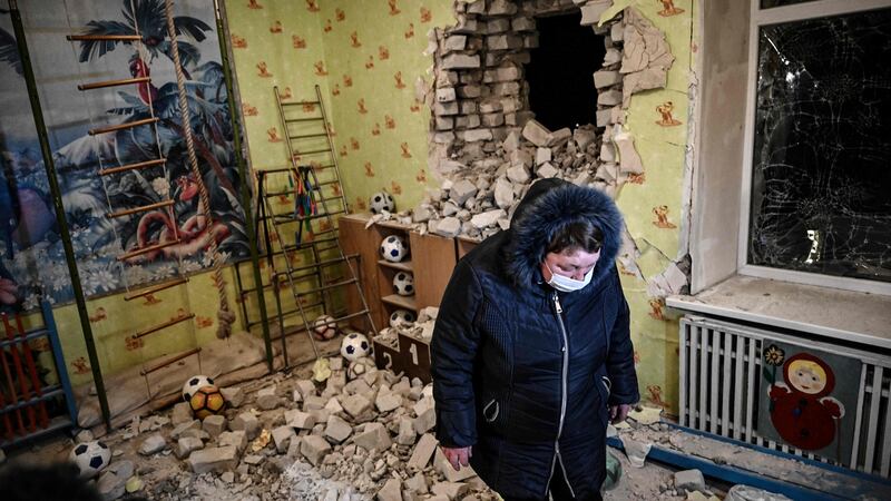 A woman stands  among debris after the reported shelling of a kindergarten in the settlement of Stanytsia Luhanska, Ukraine. Photograph: Aris Messinis/AFP via Getty Images