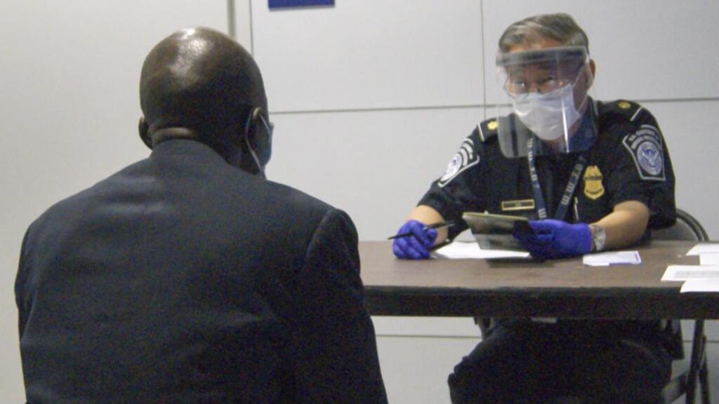A photograph made available by US Customs and Border Protection shows a CBP officer (right) examining documents and interviewing a passenger, during screening for the Ebola virus at O’Hare International Airport in Chicago. The Irish government has decided not to follow course. Photograph: EPA/US CBP