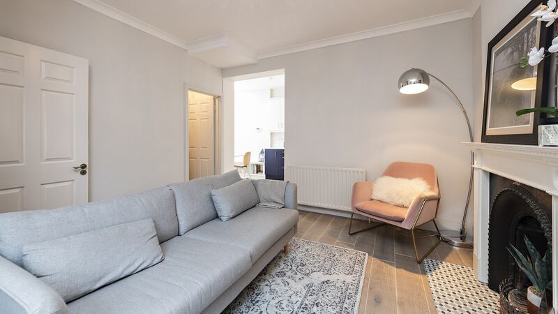 The livingroom is a good shape with seating set around an open period-style fireplace