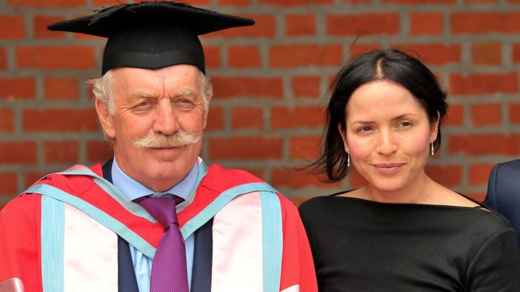 Dermot Desmond after being conferred with an honorary degree at Queen’s University Belfast yesterday, accompanied by his daughter-in-law, musician Andrea Corr. Photograph: Justin Kernoghan/Photopress