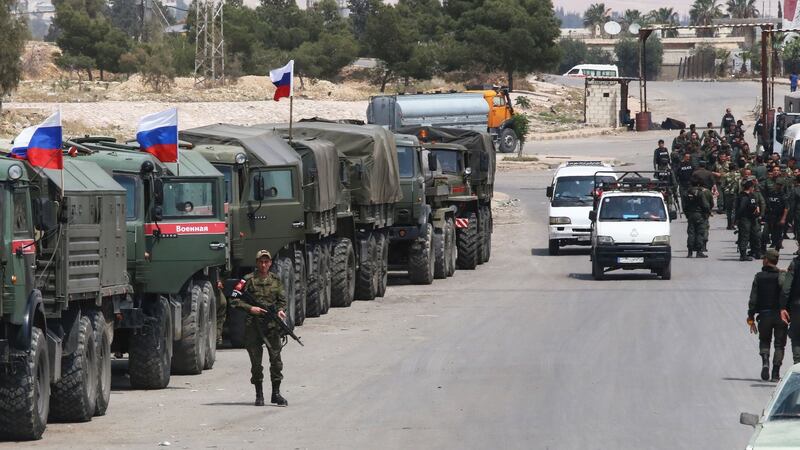 Syrian and Russian soldiers wait at the entrance of the Wafideen Camp near Damascus for the arrival of buses carrying Jaish al-Islam fighters and their family members evacuated from the Eastern Ghouta town of Douma, where a poison gas attack was reported last week. Rebels in Syria’s Eastern Ghouta surrendered their heavy weapons and their leader left the enclave, a monitor said. Photograph: Youssef Karwashan/AFP/Getty Images