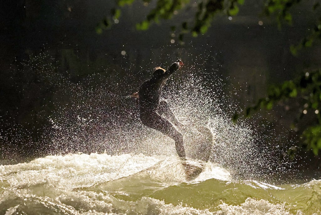 A surfer rides a wave at Eisbach creek prior to a recent river cleaning operation. Photograph: EPA