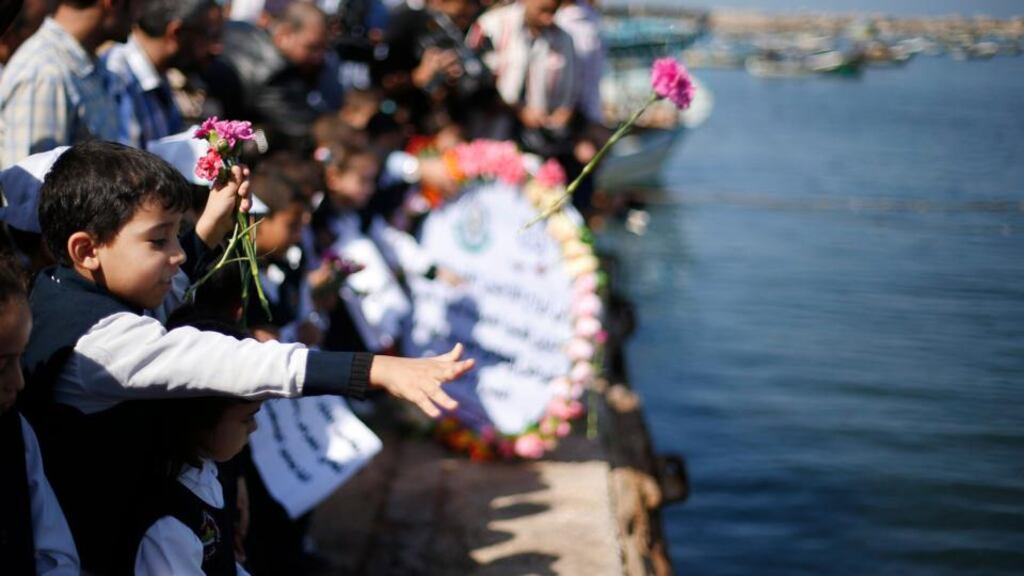 Palestinian schoolchildren throw flowers into the Seaport of Gaza City yesterday to commemorate Palestinian migrants who died after their boat sank while fleeing Syria to Italy. Photograph: Suhaib Salem/Reuters