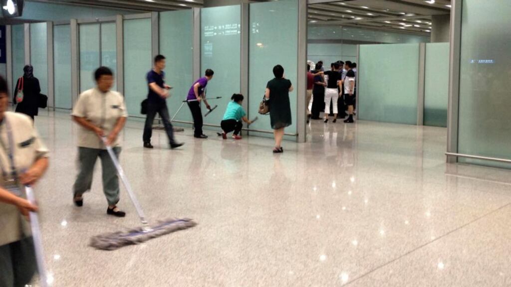 Airport staffs clean the floor and glasses at the arrival gate B where an explosion occurred at the Terminal 3 of Beijing Capital International Airport in Beijing. Photograph: Jason Lee/Reuters