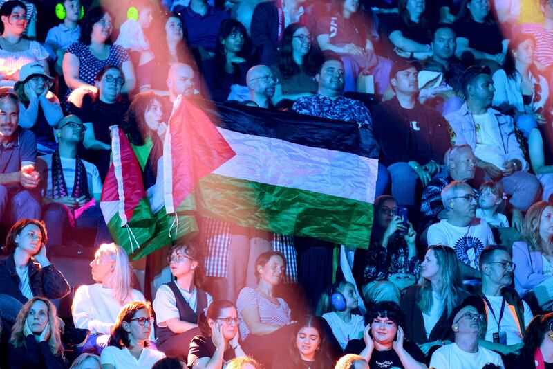 A protestor whistles and waves the Palestinian flag as Yuval Raphael representing Israel performs during the rehearsal ahead of Semi Final Round 2. Photograph: Harold Cunningham/Getty