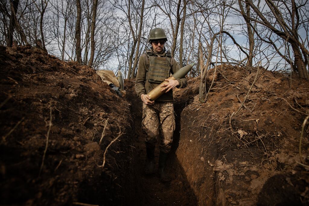 A Ukrainian soldier with the 71st Jaeger Brigade carries a howitzer as Russians advance on Avdiivka. Photograph: Tyler Hicks/The New York Times