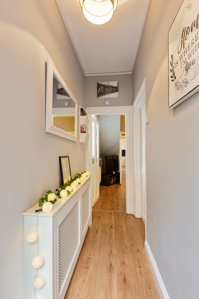 Hallway: entering the home, the ground floor has laminate wood underfoot.