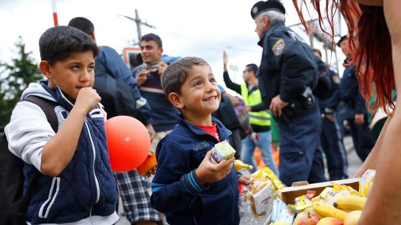 A volunteer distrubutes food to migrants at the railway station in Nickelsdorf, Austria. Photograph: Leonhard Foeger/ Reuters