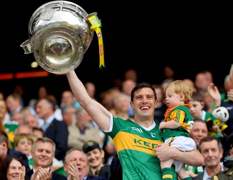 Kerry’s David Moran and his son Eli lifts the Sam Maguire after the victory over Galway at Croke Park. Photograph: James Crombie/Inpho