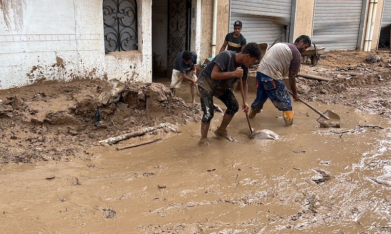 Residents attempt to clear mud from a road Derna. Photograph: EPA