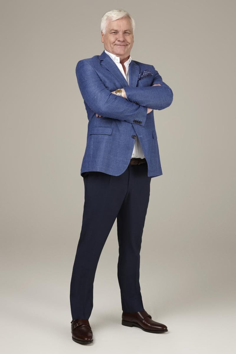 Terry Allen wears a blue linen blazer €359, navy pinhead trousers €149, belt €59, white shirt €135, floral pocket square €29, and burgundy monkstrap shoes €185, all from Louis Copeland.