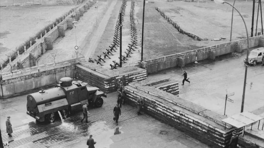 An armoured truck cleans  street  debris after  construction work to strengthen the border crossing at Heinrich-Heine-Strasse  on the Berlin Wall in  1961. Photograph: Keystone/Hulton Archive/Getty Images)