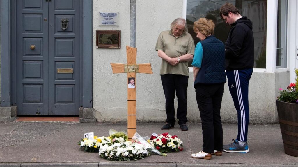 People pray at a cross erected on Friday at the scene of the killing of Det Garda Colm Horkan in Castlerea, Co Roscommon. Photograph: Colin Keegan/Collins