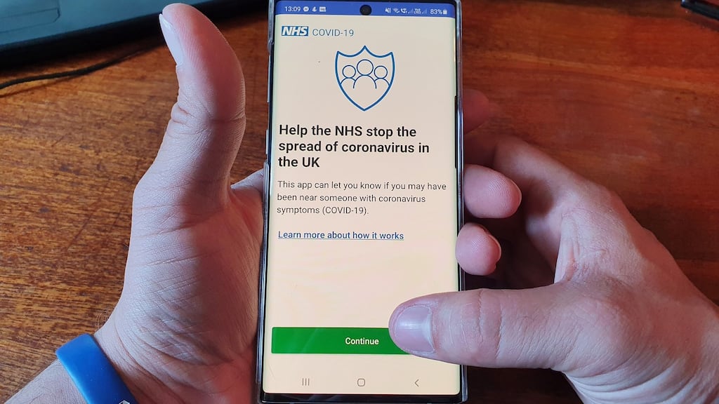 A resident of the Isle of Wight poses with his smartphone showing the newly released NHS coronavirus contact tracing app in Ryde earlier this month. Photograph: Handout / AFP via Getty Images