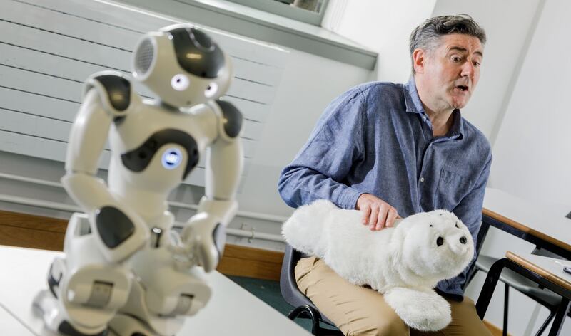 Lecturer John Pender with robots Nao and Paro. Dr Pender of IT Sligo has called for a national conversation into the use of such robots in health, education and social care settings. Photograph: James Connolly