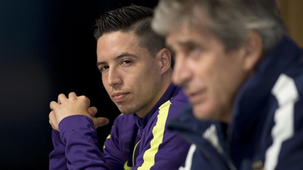 Manchester City midfielder Samir Nasri listens to manager Manuel Pellegrini during a press conference prior to the Barcelona clash. Photo: Oli Scarffoli/Getty