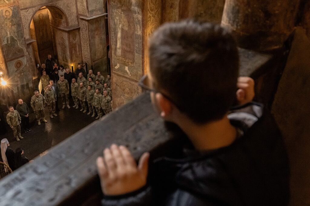 A boy looks at Ukrainian military chaplains at their graduation ceremony at Saint Sophia Cathedral in Kyiv on Friday. Photograph: Roman Pilipey/AFP via Getty Images
