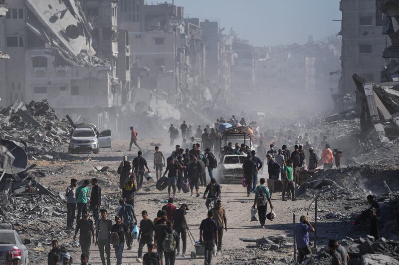 Palestinians walk along the heavily damaged Al-Jalaa Street in Gaza City. Photograph: Abdel Kareem Hana/AP