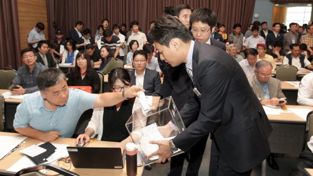 A Samsung C&T Corp stockholder casts his ballot during the general meeting of stockholders in Seoul
