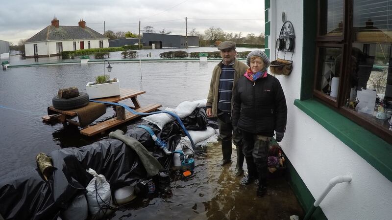 Mikey and Gertie Dunning at the rear of their farmhouse in Golden Island outside Athlone. Their home is entirely surrounded by water and they are on 24-hour watch to monitor sandbags and electric pumps. Photograph: Bryan O’Brien