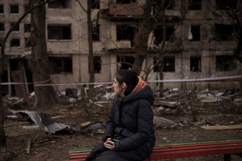A resident sits outside a destroyed building in Kyiv after it was hit by artillery shelling. Photograph: Felipe Dana/AP