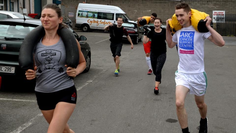 Gym member Zofia Siok with Ciarán D’Arcy running with sandbags. Photograph: David Sleator
