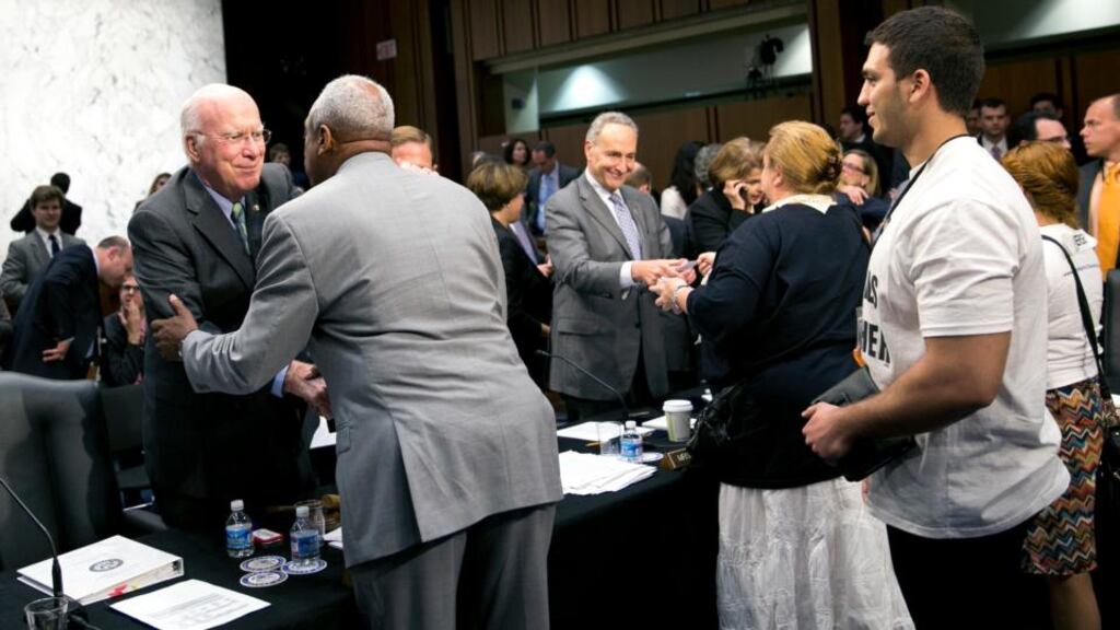 Senate Judiciary Committee chairman Patrick Leahy, left, and Senator Chuck Schumer, centre, shake hands with supporters after the committee approved legislation to overhaul US immigration laws, in Washington, last night. Photograph: Drew Angerer/The New York Times