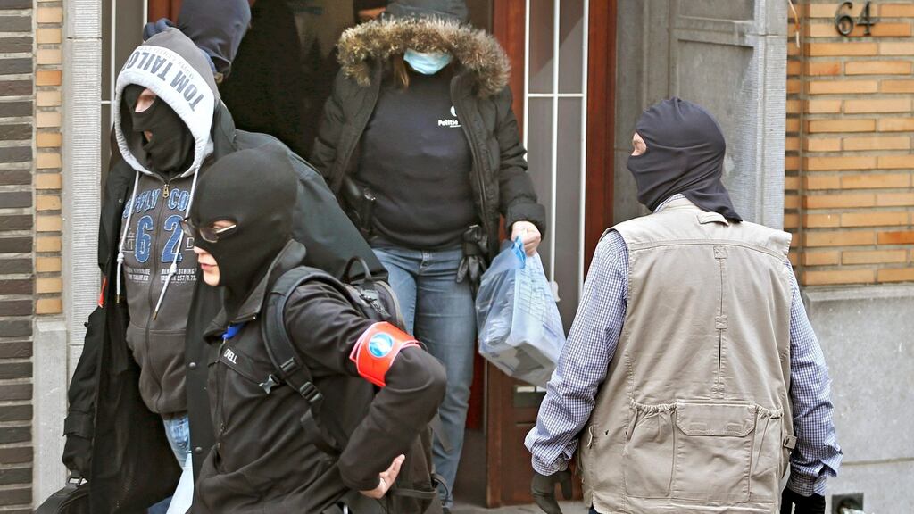 Masked Belgian police remove evidence from a building in Anderlecht following Tuesday’s bomb attacks in Brussels. Photograph: Charles Platiau/Reuters