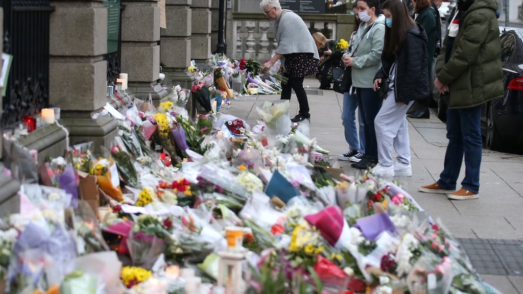 People pay their respects to murdered national school teacher Ashling Murphy utside Leinster House on Saturday where flowers, messages and candles have been left. Photograph: Stephen Collins/Collins Photo