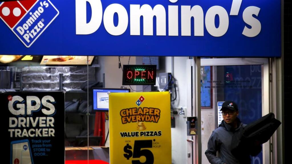 A worker carries a pizza for delivery at a Domino’s pizza store in Sydney:   Fast food  companies are making healthy profits and boldly innovating in the unlikely market of Australia. Photograph: REUTERS/David Gray