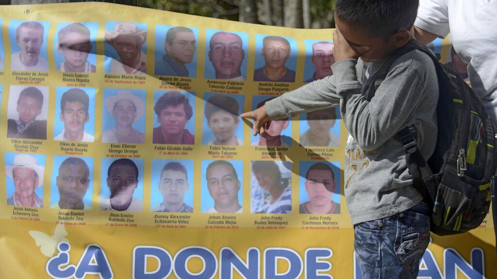 A child cries as he point at a portrait on a banner depicting disappeared people during a demo of the “Madres de la Candelaria” (Candlemas Mothers) --a social movement that makes public denunciations of forced disappearances in Colombia. Photograph: Raul Arboleda/AFP/Getty Images