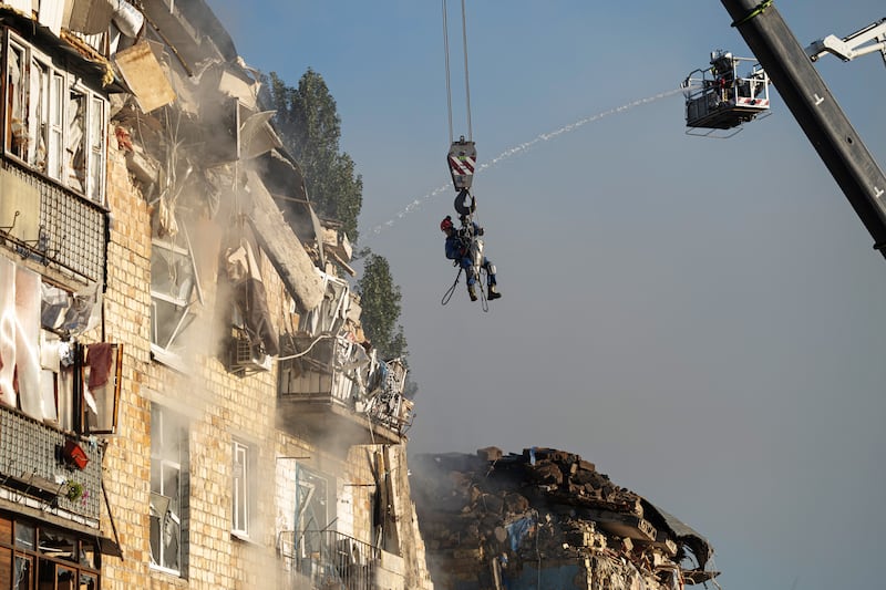Emergency service workers at the site a Russian air strike on a residential building in Kyiv. Photograph: Andrew Kravchenko/Bloomberg