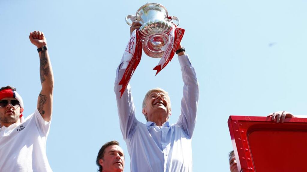 Arsenal manager Arsene Wenger holds the FA Cup trophy during a victory parade after the win against Hull City. Photograph: Andrew Winning/Reuters