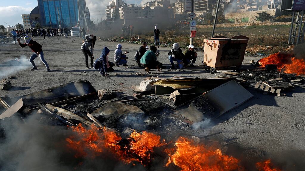 Palestinians take cover during clashes with Israeli troops in the Israeli-occupied West Bank. Photograph: Mohamad Torokman/Reuters
