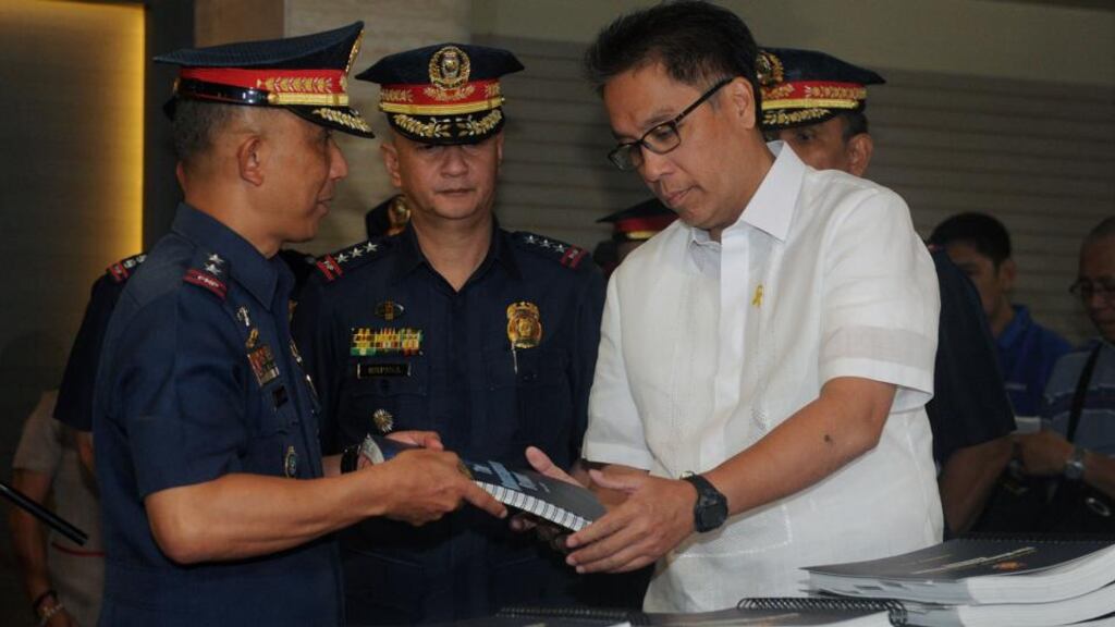 From left: Philippines police director Benjamin Magalong and deputy director general Leonardo Espina  hand a copy of their findings into the January 25th incident  to department of the interior and local government secretary Manuel Roxas at police headquarters in Manila yesterday. Photograph: Jay Directo/AFP/Getty Images