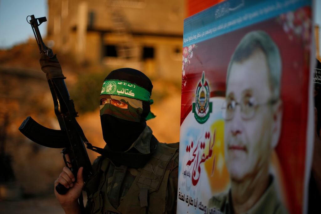 A Hamas militant holds a poster of Maysara Abu Hamdiya before a protest in the northern Gaza Strip yesterday. Photograph: Suhaib Salem/Reuters