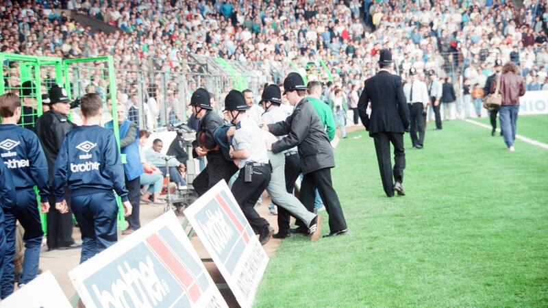 A fan is arrested during a Manchester City match at Maine Road in 1989. Photo: Reid/Mirrorpix/Getty Images