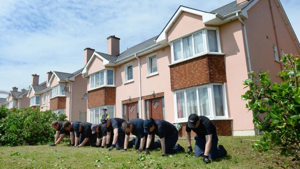 Gardaí examine the garden outside the house in Killorglin, Co Kerry, where the bodies of Jolanta Lubiene and her daughter, Enrika, were found. Gardaí are understood to be hopeful that the killer may have left fingerprint or DNA evidence in the house in the course of the attack. Photograph: Domnick Walsh/Eye Focus
