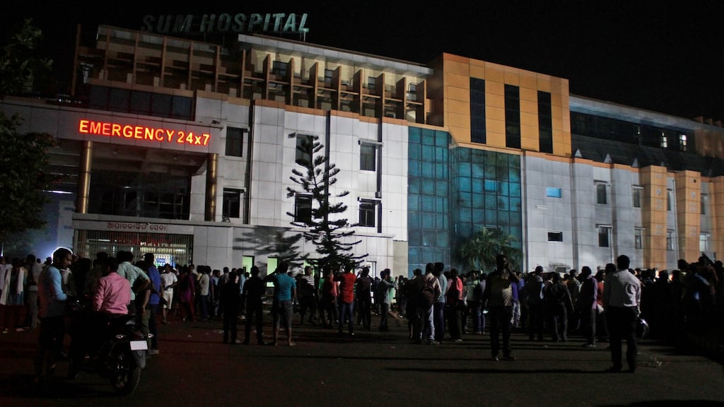 People gather outside the private Sum Hospital after a fire broke out in its intensive care unit in Bhubaneswar in the eastern Indian state of Orissa on Monday. Photograph: AP