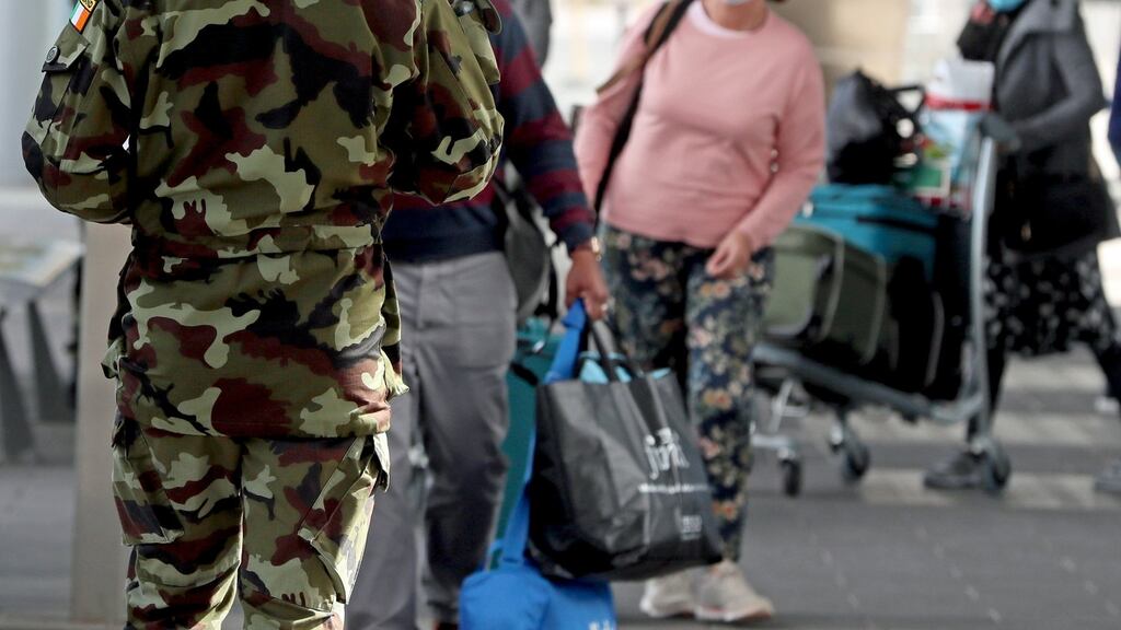 A member of the Defence Forces directs passengers arriving at Dublin Airport to a mandatory 12-day hotel quarantine. Photograph: Brian Lawless/PA Wire